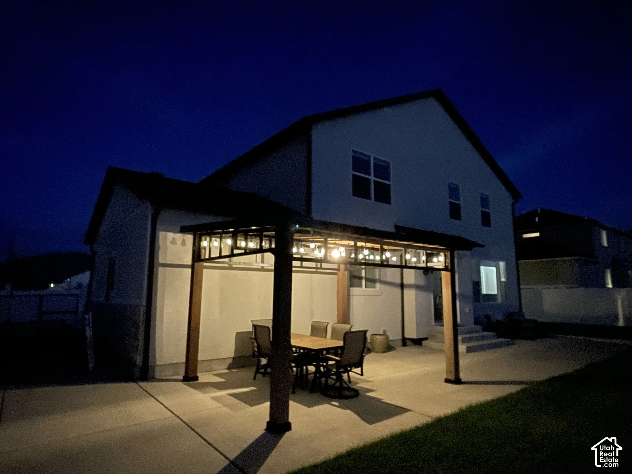 Patio space with a built-in pergola featuring decorative string lighting