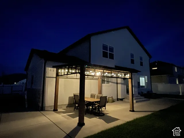 Patio space with a built-in pergola featuring decorative string lighting