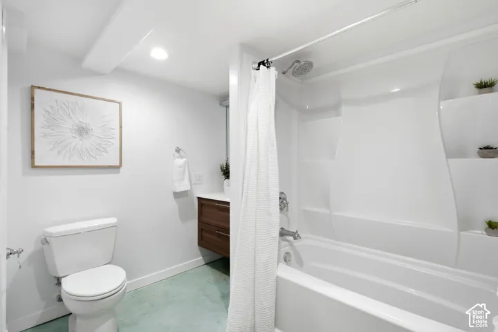 Integrated bathtub and shower combination with built-in shelving, white floating vanity with wood-finish cabinetry, and recessed lighting