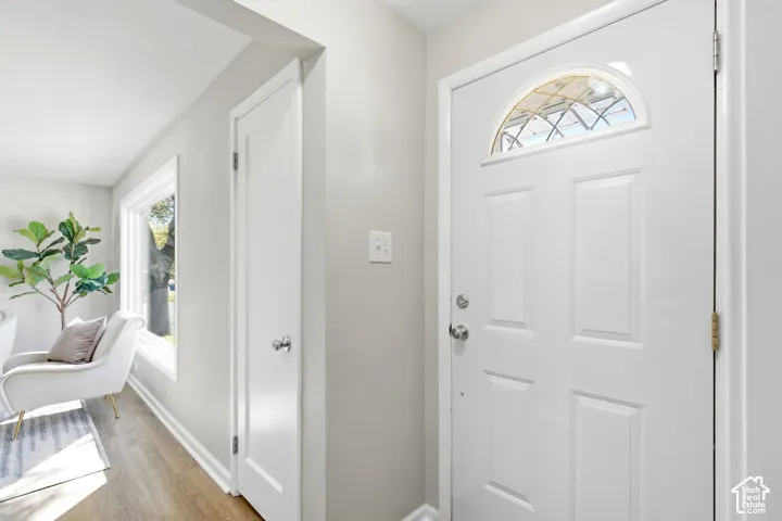 White four-panel entry door with an arched decorative glass transom