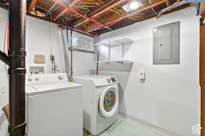Dedicated laundry area featuring a utility window, exposed ceiling joists, and built-in wall shelving