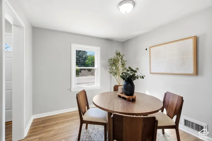 Neutral wall color, wood-finish flooring, white trim, recessed lighting, and a framed window