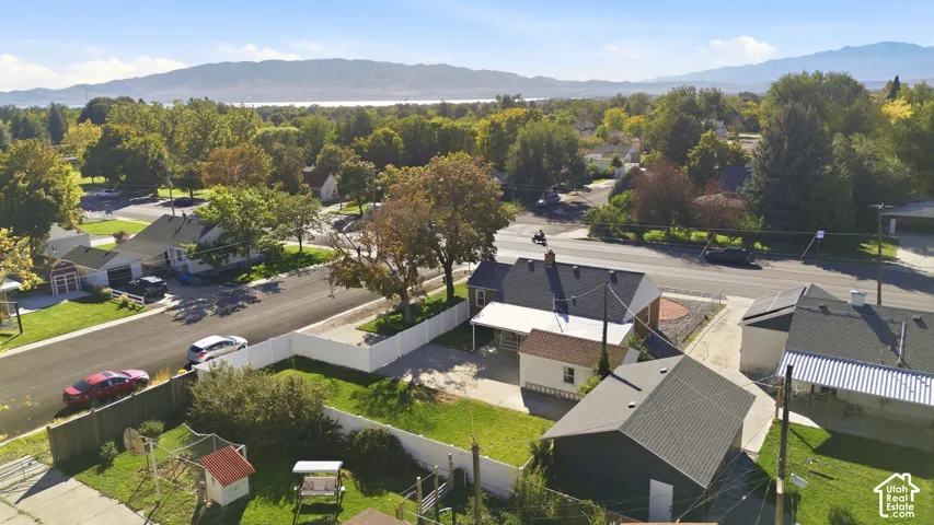 Expansive property with mature trees, a detached garage, and a white privacy fence