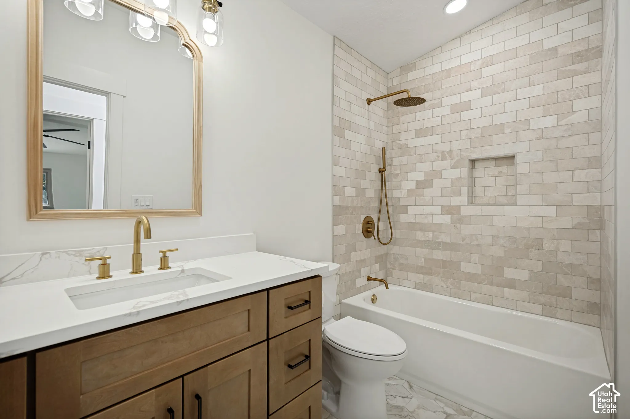 Bathroom featuring a wood-finish vanity with a white countertop and gold-tone fixtures