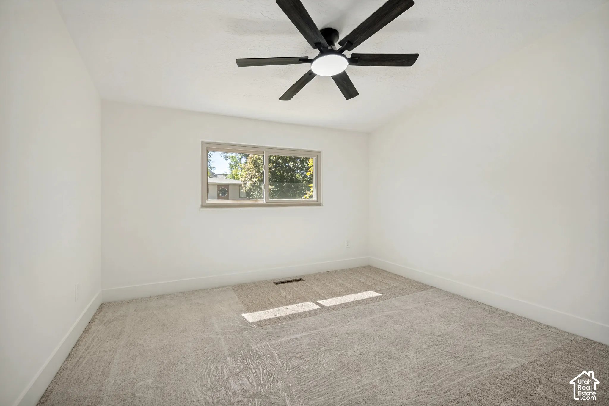 Textured carpeting and a ceiling-mounted fan with integrated lighting