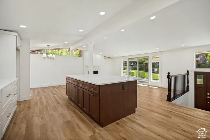 Spacious open-concept area featuring light wood-finish flooring, white walls, and recessed lighting