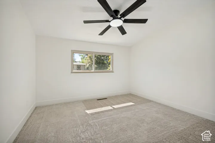 Textured carpeting and a ceiling-mounted fan with integrated lighting