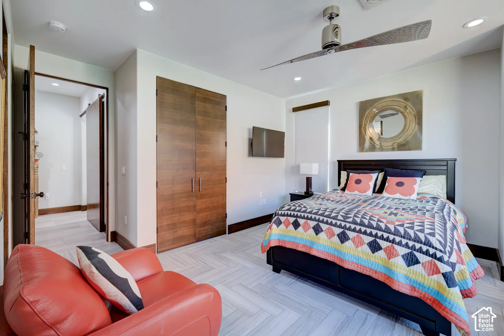 Herringbone-patterned flooring, recessed lighting, and a contemporary ceiling fan
