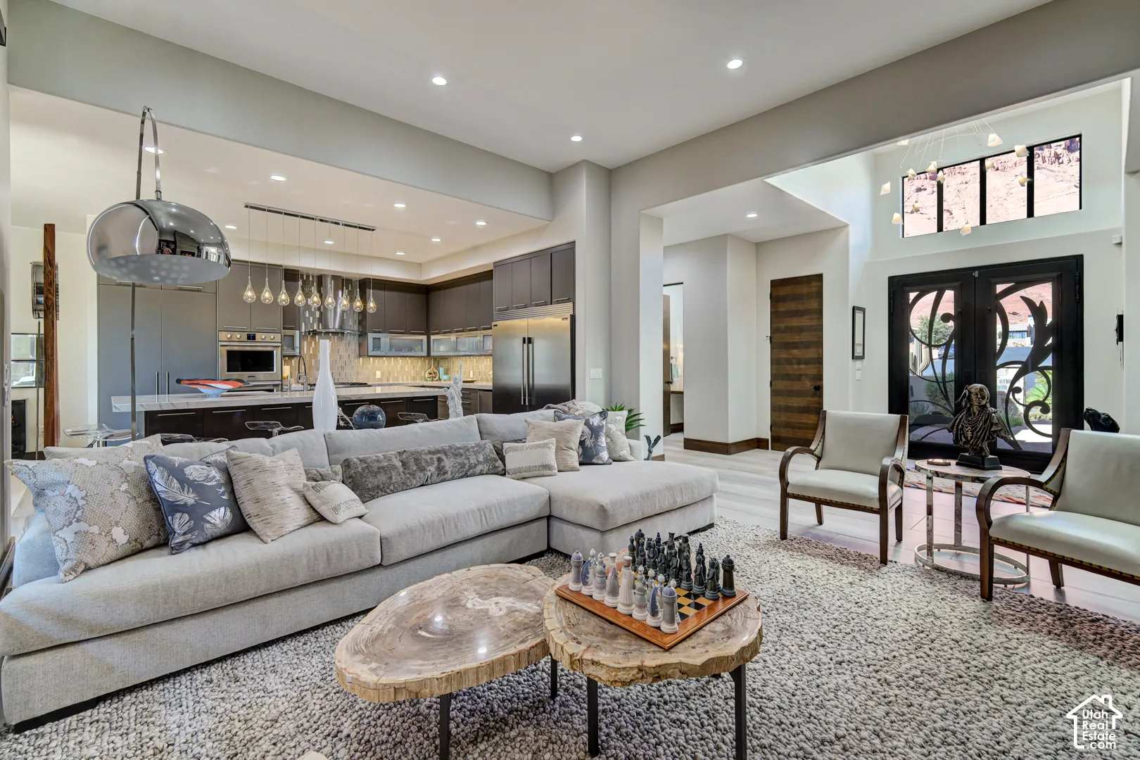 Open-concept living space featuring a high ceiling, recessed lighting, and a modern kitchen with dark cabinetry