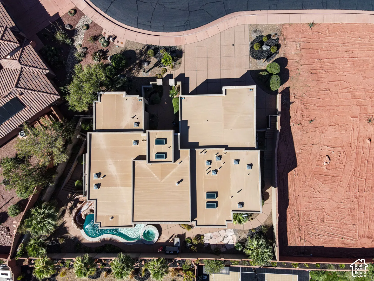 Curved swimming pool with integrated spa, multiple skylights, and extensive hardscaping