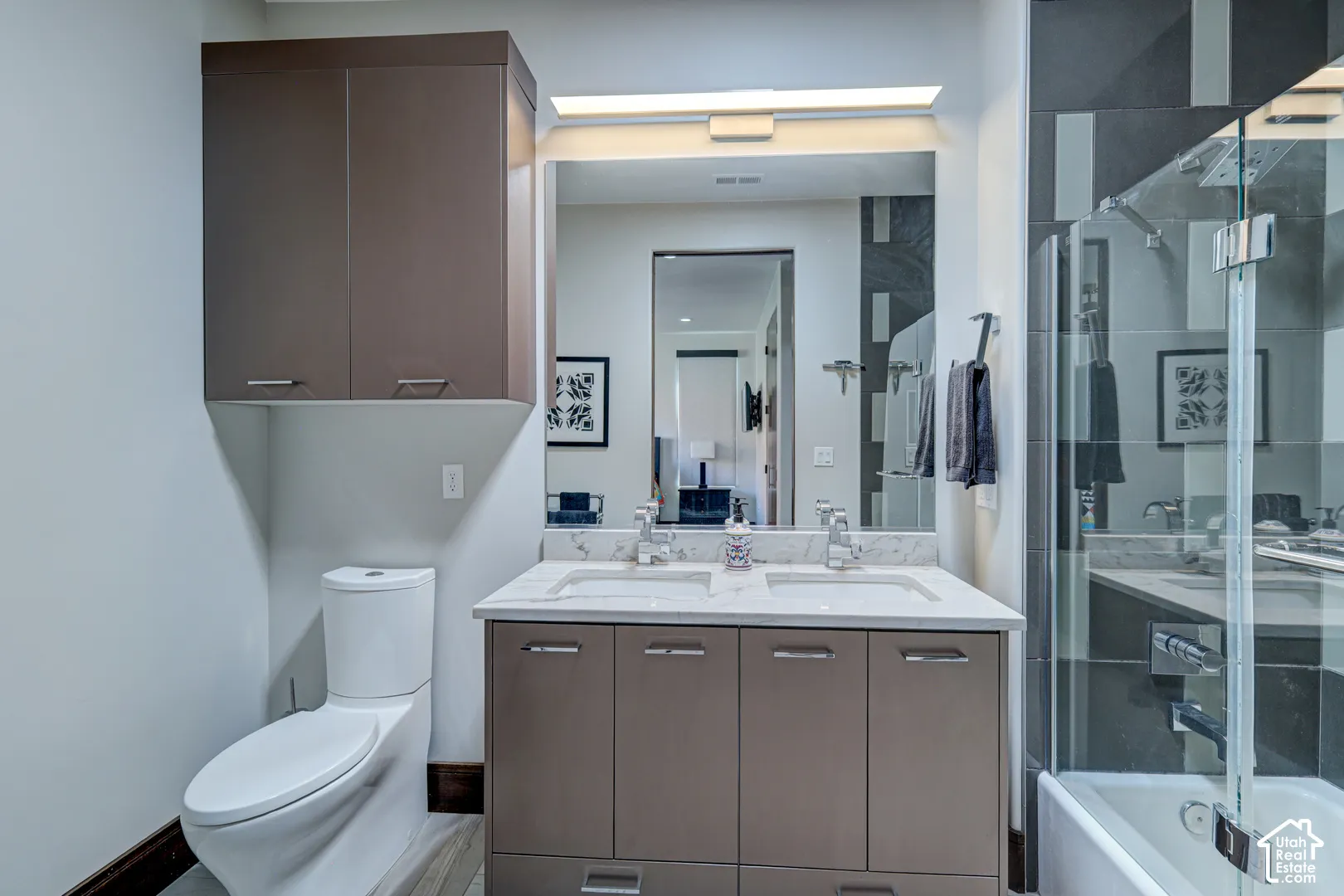 Dual vanity with undermount sinks, stone countertop, and an integrated mirror