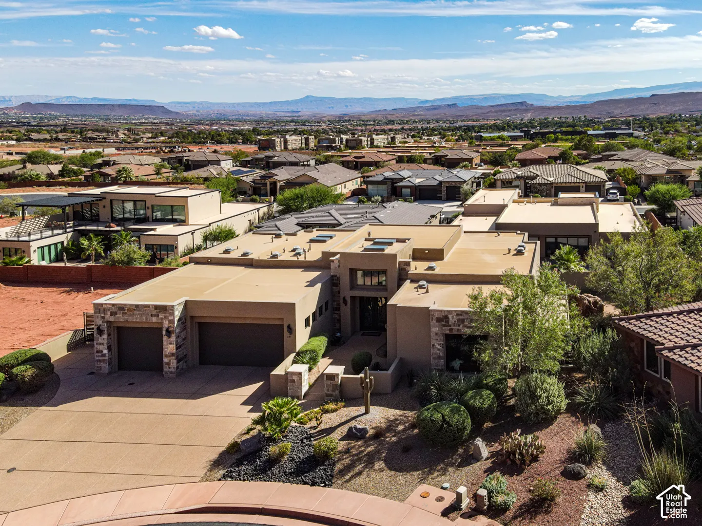 Southwestern architectural style with a flat roofline, integrated two-car garage, and desert landscaping