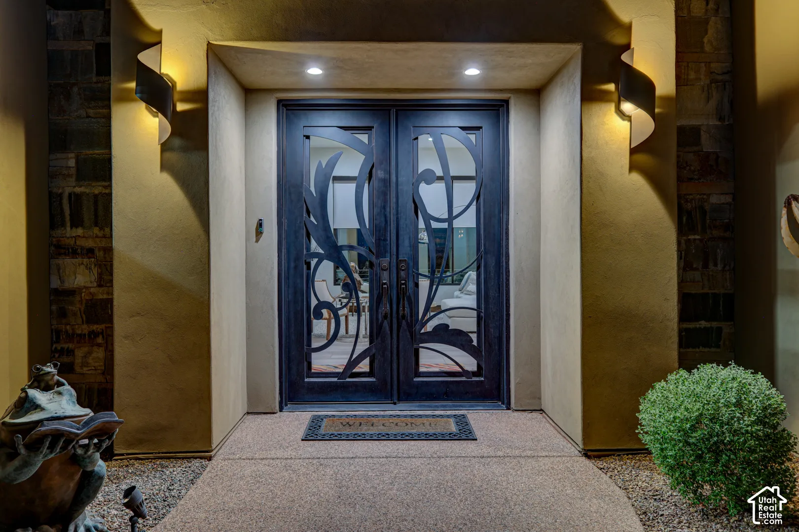 Double entry doors with intricate wrought iron detailing and glass panels