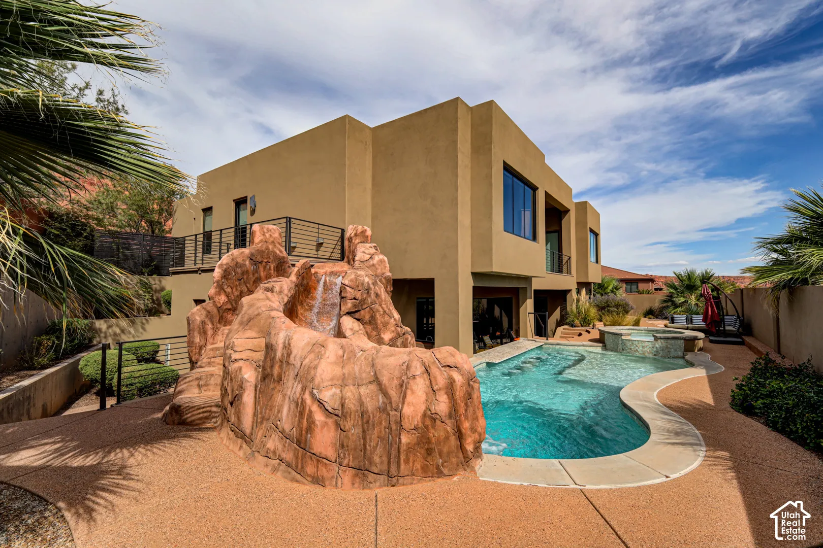 Multi-level exterior with a desert-inspired pool and integrated rock waterfall feature