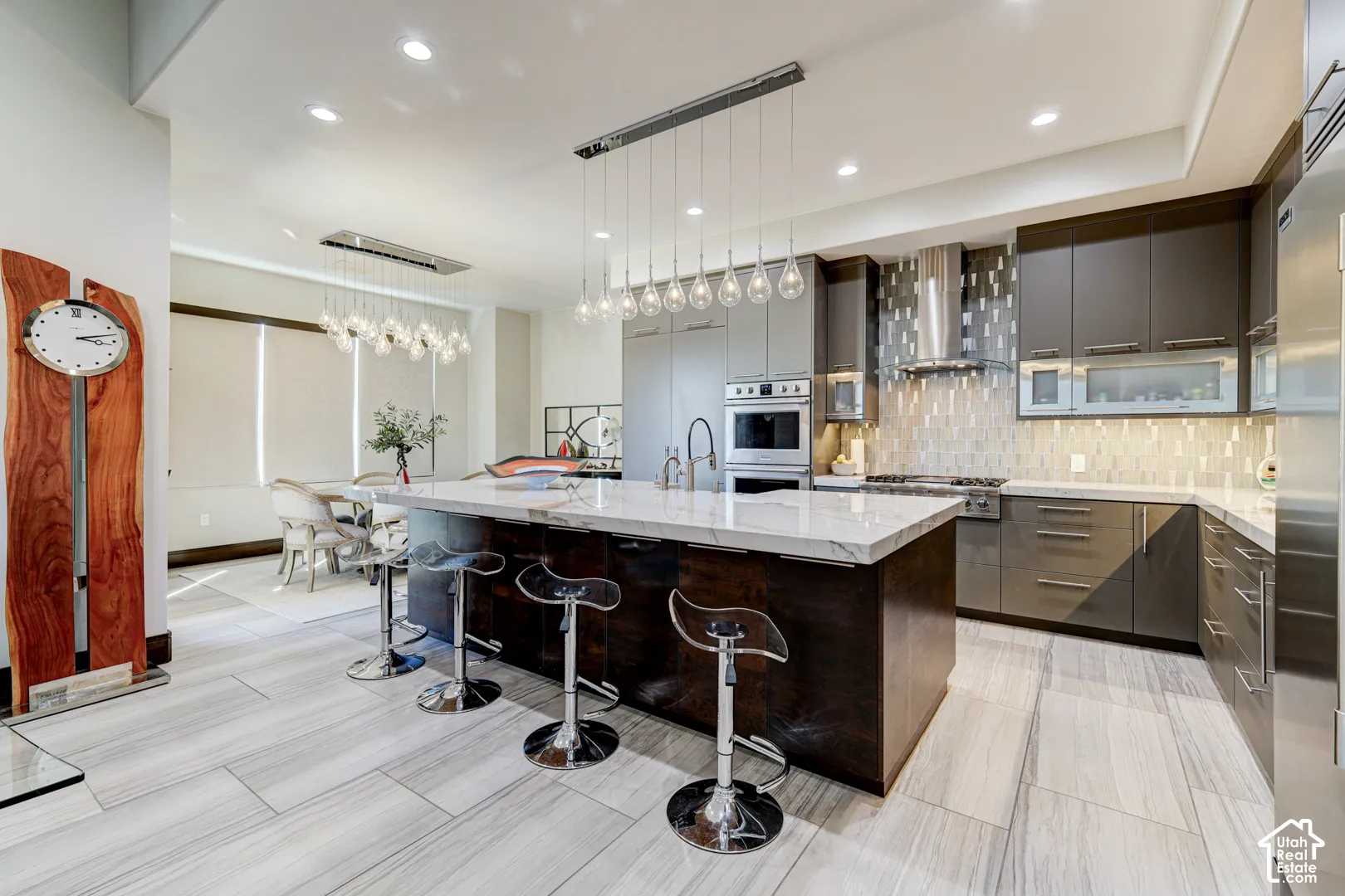 Gourmet kitchen with an expansive island, white countertop, dark wood-finish cabinetry, and light gray cabinetry