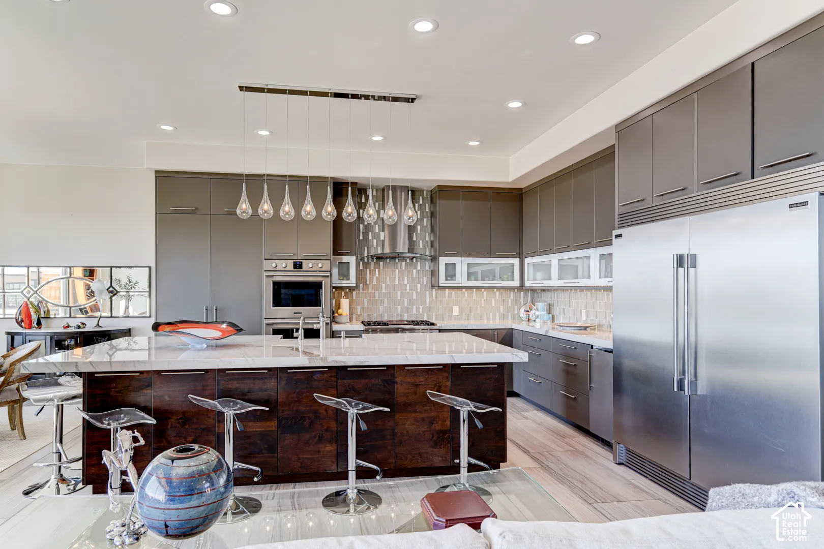 Gourmet kitchen with a large island, stainless steel appliances, recessed lighting, and pendant light fixtures