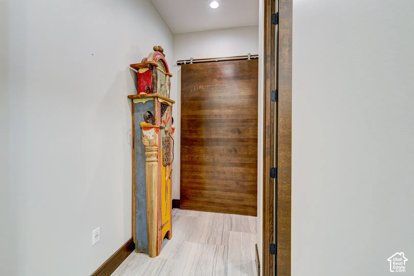 Wood-finish sliding barn door with black hardware, complementing wood-finish door frame