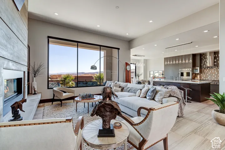 Open concept living space featuring a linear fireplace, large picture window, recessed lighting, and tile flooring