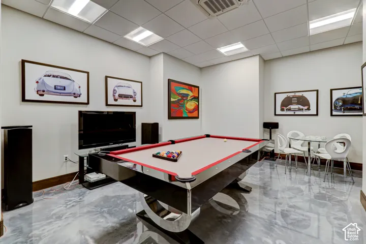 Recessed ceiling lighting, white ceiling tiles, light-toned walls, and a glossy, reflective flooring surface