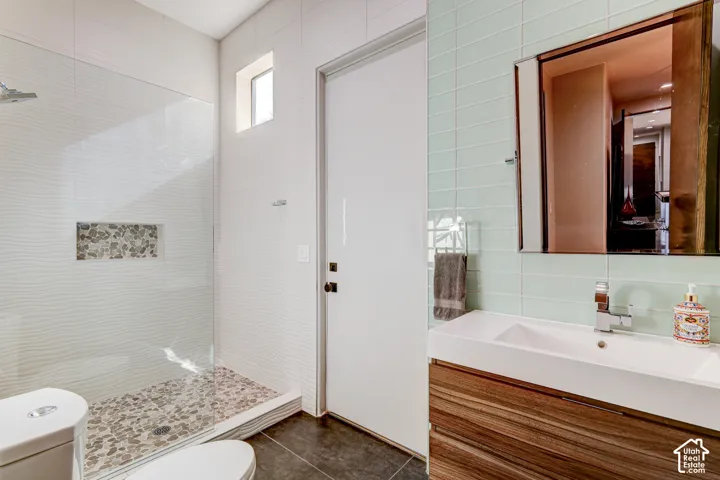 Glass-enclosed shower with pebble-tile floor and recessed shelf