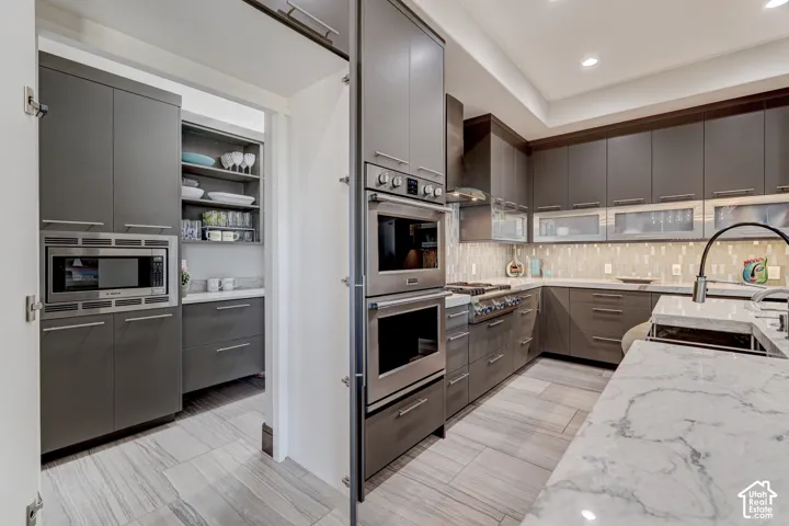 Gourmet kitchen with custom cabinetry, integrated double ovens, and a built-in microwave
