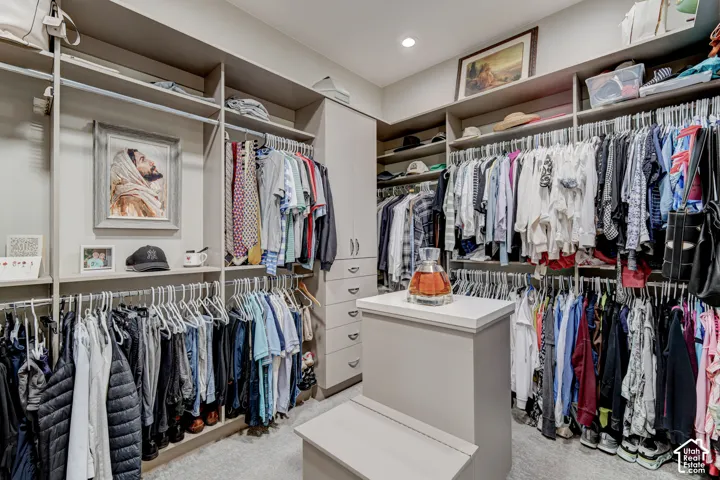 Custom closet system with multiple hanging rods, integrated shelving, built-in drawers, and a central island