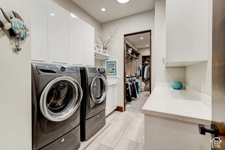 White upper cabinetry, light-toned wood-finish flooring, recessed lighting, and a white countertop