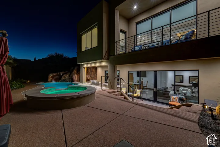 Multi-level rear patio with a built-in spa, freeform pool, and rock waterfall feature