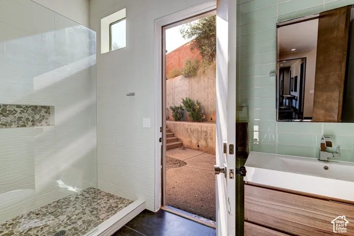 Walk-in shower with pebble tile flooring and integrated niche