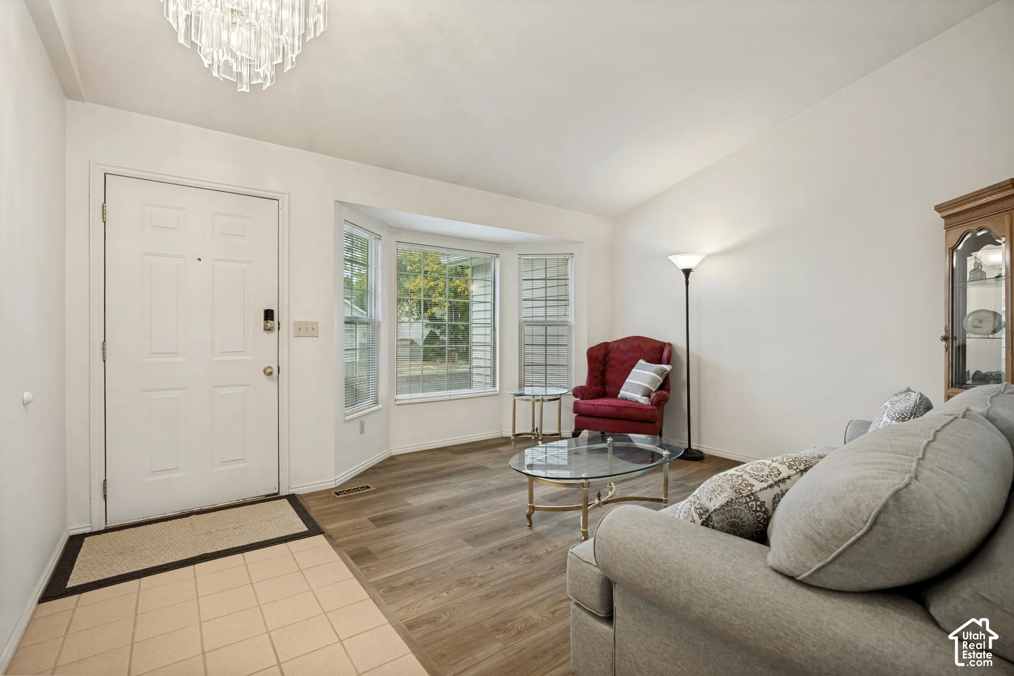 Entry foyer with tile flooring leading to wood-finish flooring