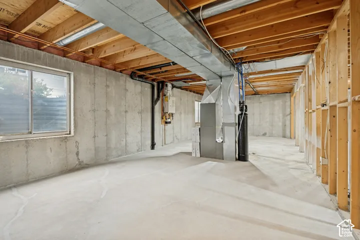 Concrete foundation walls, exposed wood ceiling joists, concrete flooring, and an egress window