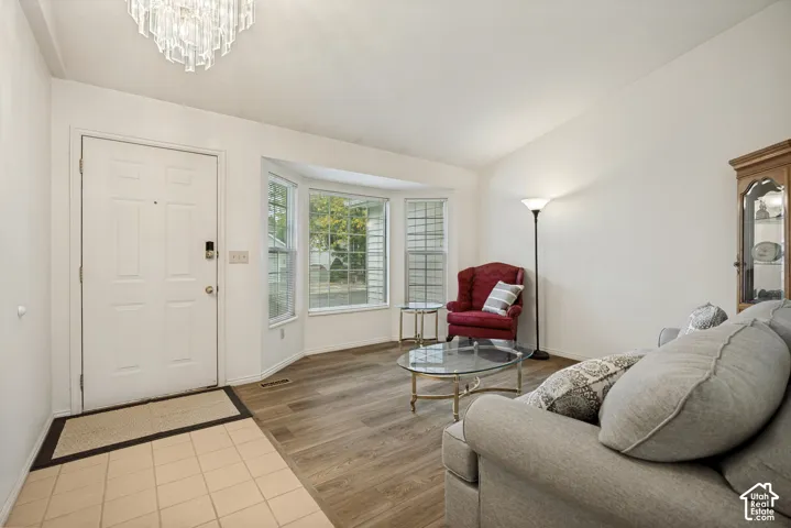 Entry foyer with tile flooring leading to wood-finish flooring