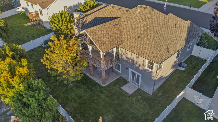 Expansive backyard with a manicured lawn, mature trees, and a privacy fence