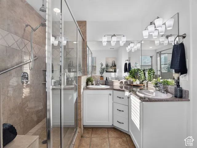 Walk-in shower with glass enclosure and tile surround