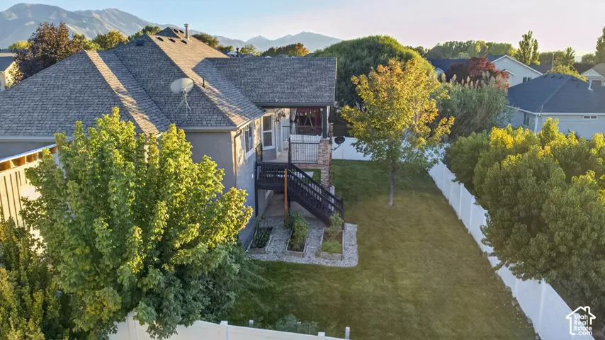 Expansive backyard featuring a manicured lawn, established trees, and a white privacy fence