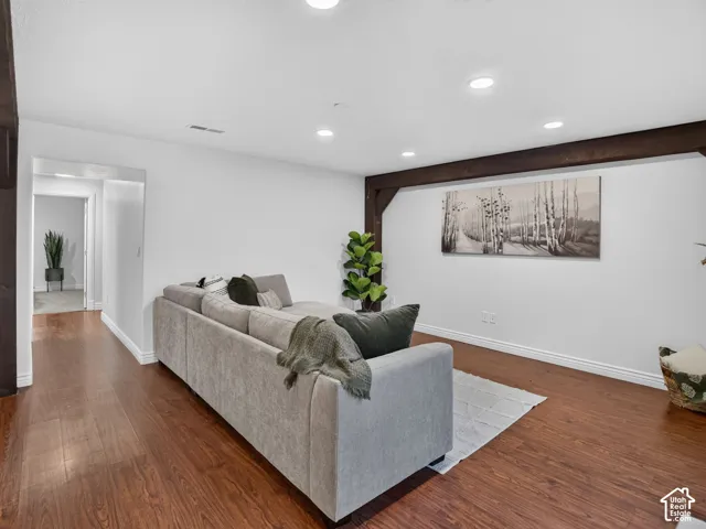 Wood-finish flooring, recessed lighting, and exposed wood beams