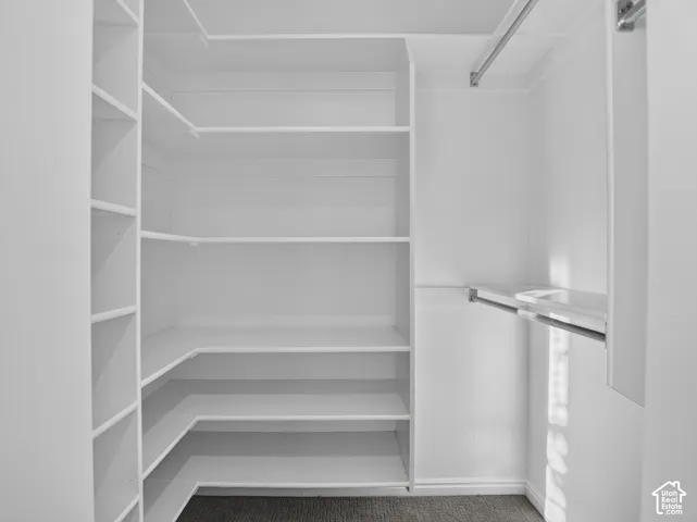 His and hers closets with Integrated shelving, multiple hanging rods, and fresh carpeting