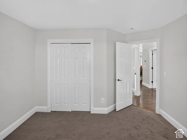 Spacious bedroom featuring pristine white six-panel closet doors, fresh carpet, and neutral wall finishes