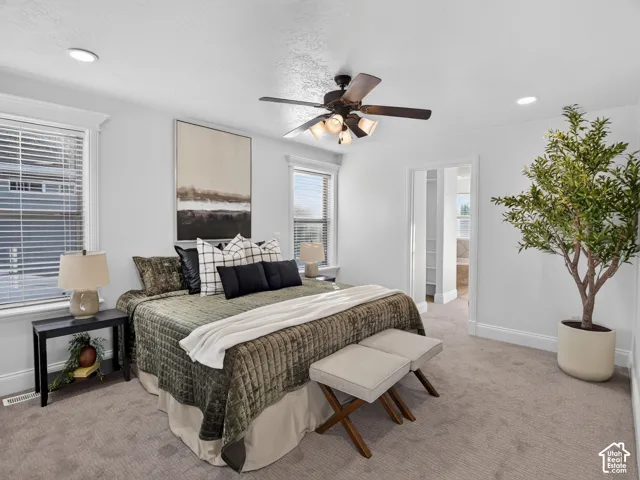 Recessed lighting, ceiling fan, double windows with blinds, and light-colored carpet