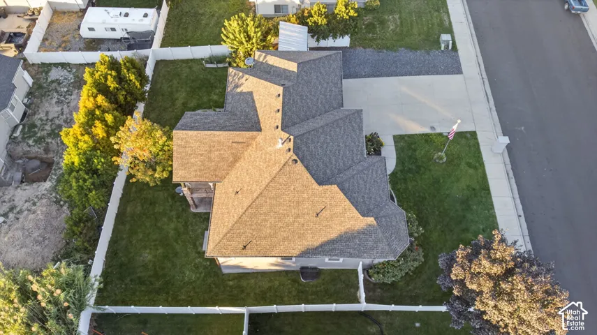 Expansive lot featuring a large lawn area, mature trees, and a concrete driveway