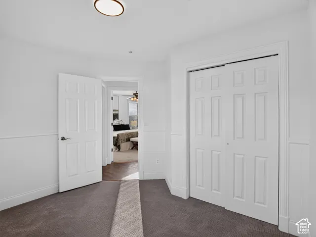 White paneled walls with wainscoting, a flush-mount ceiling light, and six-panel closet doors