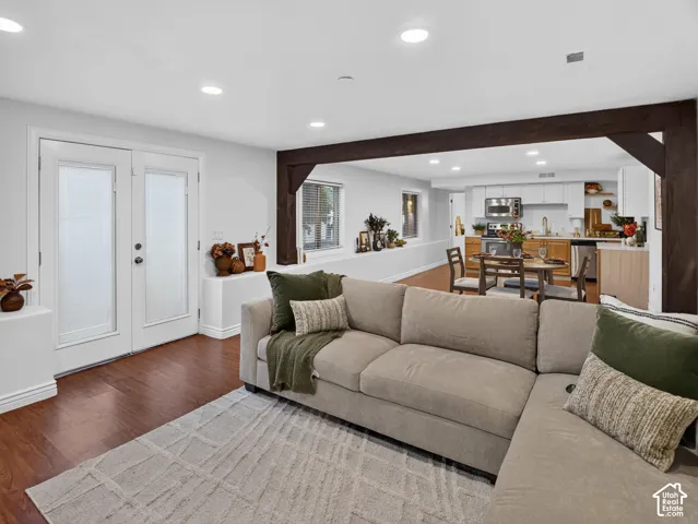 Open-concept living space featuring wood-finish flooring, recessed lighting, and exposed structural beams