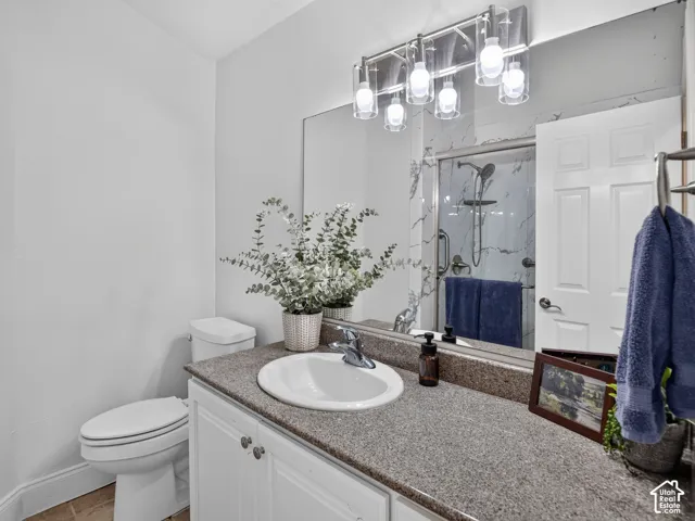 Upstairs Bathroom vanity with a granite-style countertop, undermount sink, and white cabinetry