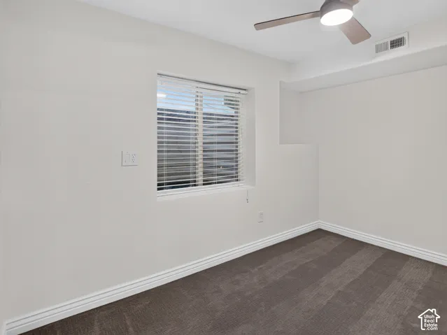 Neutral wall paint with textured carpeting, a window with blinds, and a ceiling fan with integrated lighting