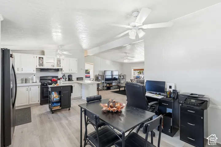 Kitchen with white cabinetry, black appliances, light wood-finish flooring, and a ceiling fan