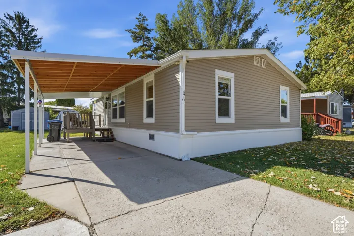 Exterior featuring tan siding, white trim, and a white foundation
