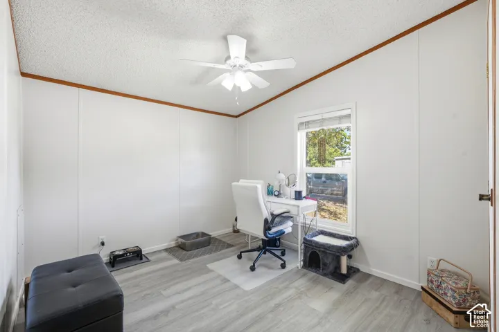 Wood-finish plank flooring, ceiling fan with integrated lighting, and a window with white trim