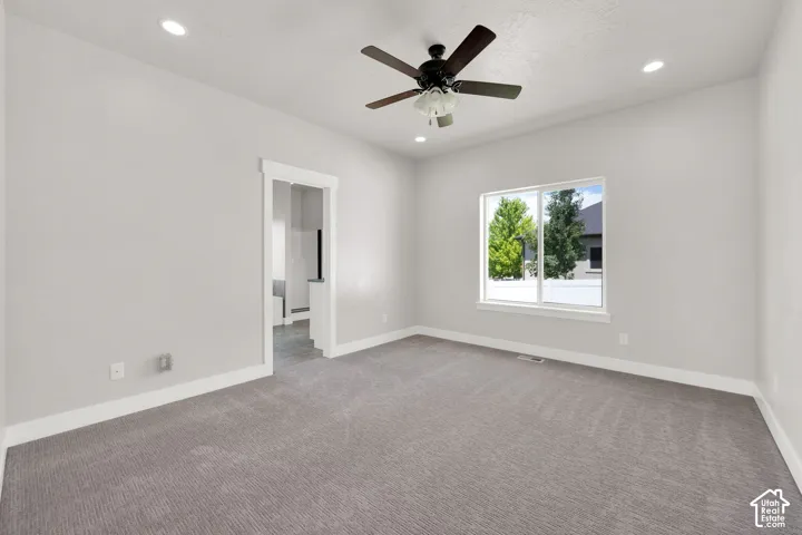 Recessed ceiling lighting, ceiling fan with light fixture, gray textured carpeting, white trim, and a window with a white frame