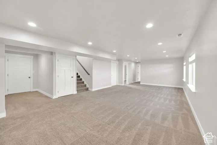 Expansive open-concept room with recessed lighting, light neutral-toned walls, and multiple windows