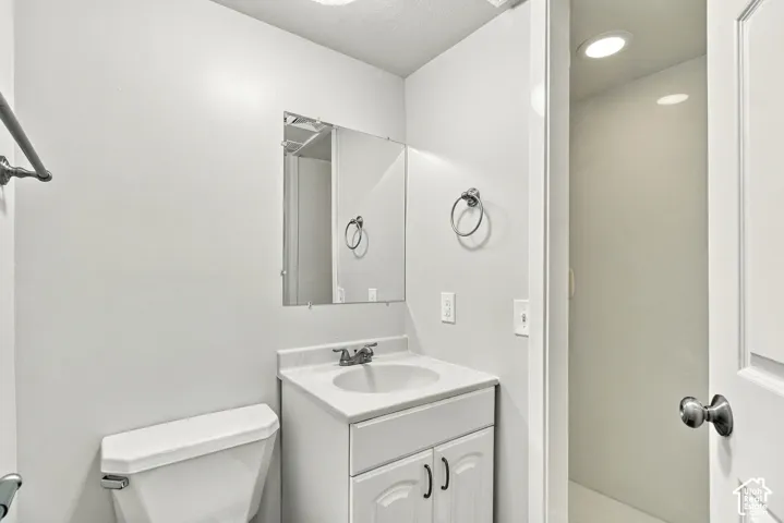 White vanity with dual-door cabinetry, integrated sink, and chrome faucet